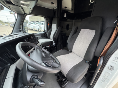 Cab interior of a 2021 Freightliner PT126064ST, showing steering wheel, driver's seat, passenger seat, center console, and dashboard with fabric upholstery.