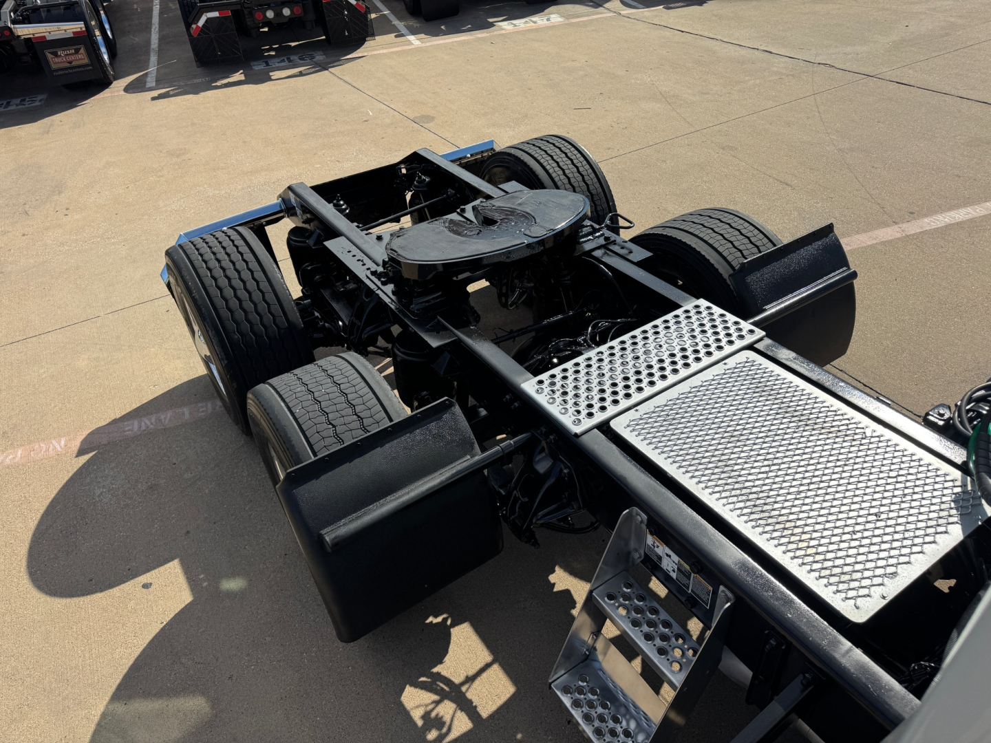 Kenworth T680 chassis view showing rear axles and metal catwalk platform with perforated steps