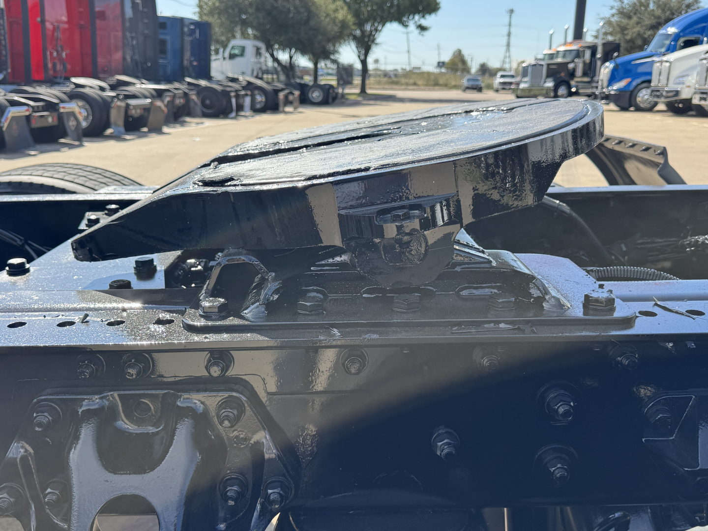 Kenworth T680 truck cab area showing fifth wheel hitch and mount assembly with hydraulic components
