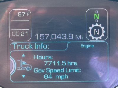 Dashboard display showing 157,043.9 miles, hours 7711.5 hrs, governor speed limit 64 mph, engine gear N, N and gear icon, outside temperature 87°F, truck info section.