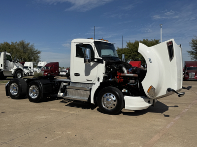 Kenworth T680 conventional daycab with hood open showing engine and components, white cab, chrome wheels, side steps, front view.