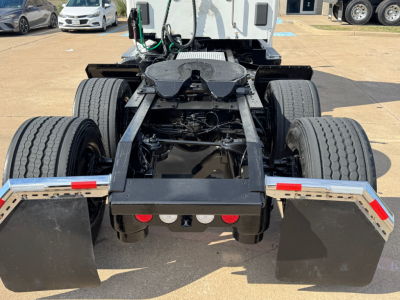 Kenworth T680 rearview showing chassis and dual rear axles with mud flaps and fifth wheel mount.