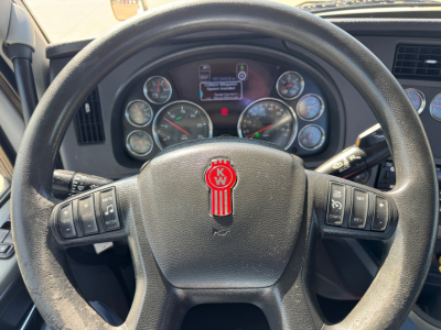 Kenworth T680 steering wheel and dashboard view showing gauges and control stalks.