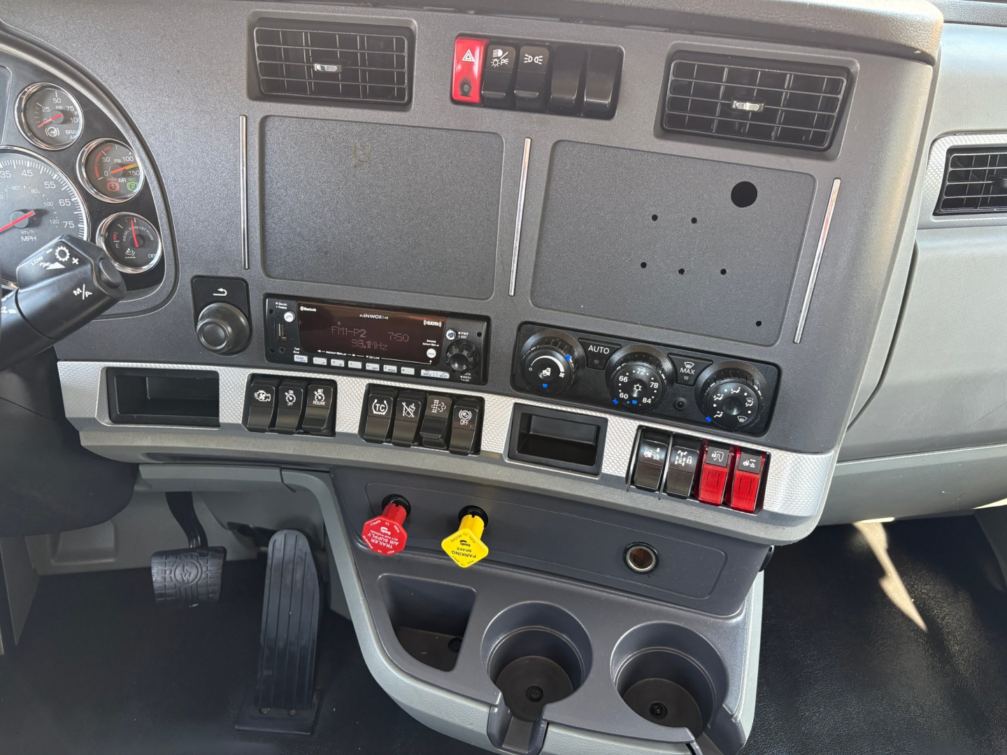 Dashboard area of a 2022 Kenworth T880 daycab showing instrument cluster, center console, and switches.