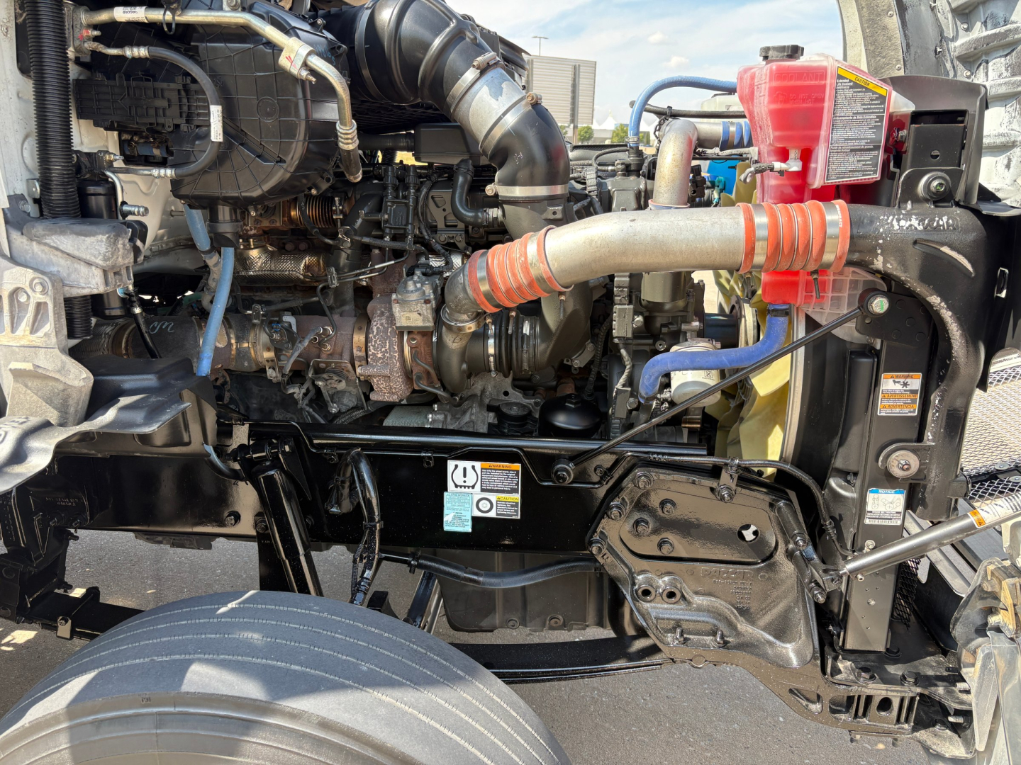 Kenworth T880 engine bay view showing turbo piping, coolant reservoir, and air intake components.