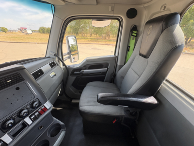 Kenworth T880 cab interior view showing front seats and dashboard (driver's seat with armrest).