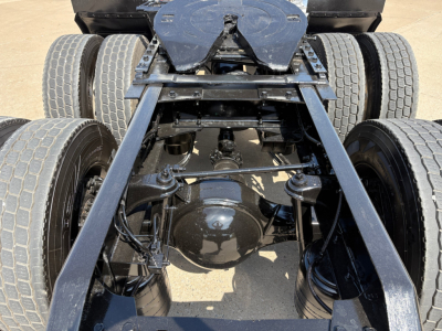 Kenworth T880 chassis and rear axle view showing dual rear axles and fifth wheel mounting with drivetrain components visible.