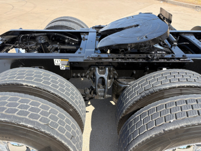 Kenworth T880 chassis view showing dual rear axles and fifth wheel mounting with exposed frame and suspension components.