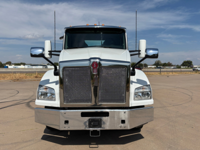 Kenworth T880 conventional daycab front view showing large chrome grille, dual side mirrors, and metal bumper; front of the truck with Kenworth emblem.
