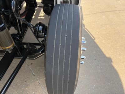 Front view of a Kenworth T880 wheel with a closely spaced tread and drive components visible near the suspension.