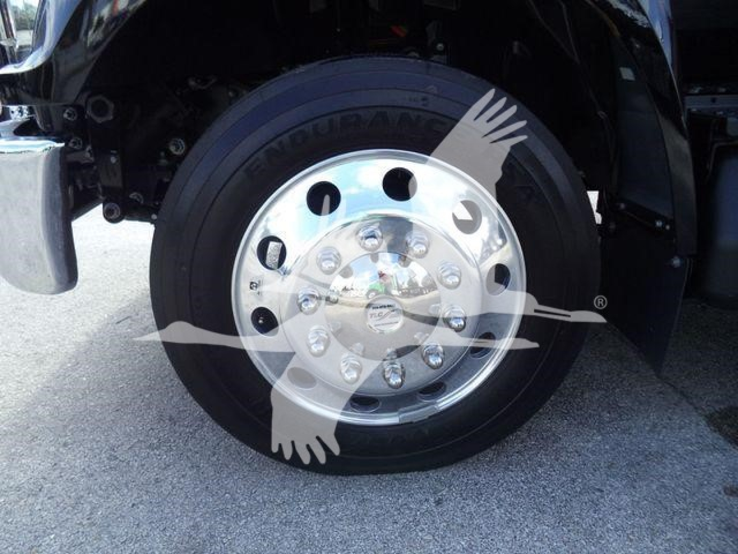 Ford F-750 front wheel with shiny chrome hub, Goodyear tire, wheel well, and fender partially visible.