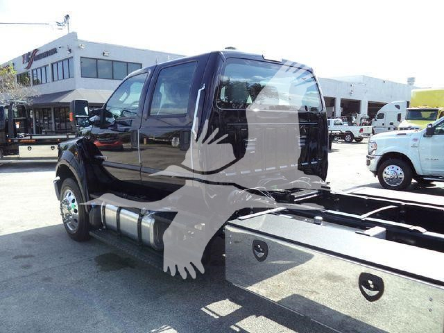 Ford F-750 rollback truck cab and chassis showing side view and dual fuel tanks with cab doors open.