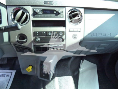 Dashboard of a Ford F750 Super Duty truck showing center stack with radio, climate controls, circular vents, and lower storage area.