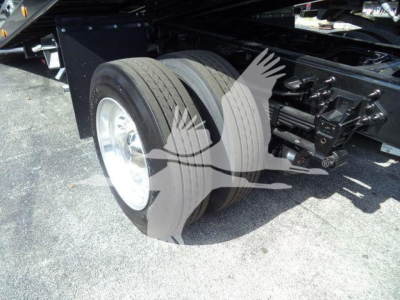 Ford F-750 rollback truck rear dual rear wheels and suspension visible; wheel assembly; hydraulic components and frame rail; no legible text on image