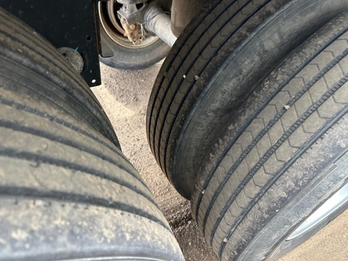 Tandem axle trailer wheel area showing dual rear tires with tread and dirt, part of a Timpte hopper trailer.