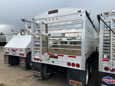Timpte Super Hopper trailer rear view with polished metal side panels, black mud flaps, and Timpte branding on the tailgate.