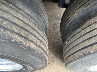 Timpte hopper trailer wheels with visible tread and mud, dual-axle configuration.