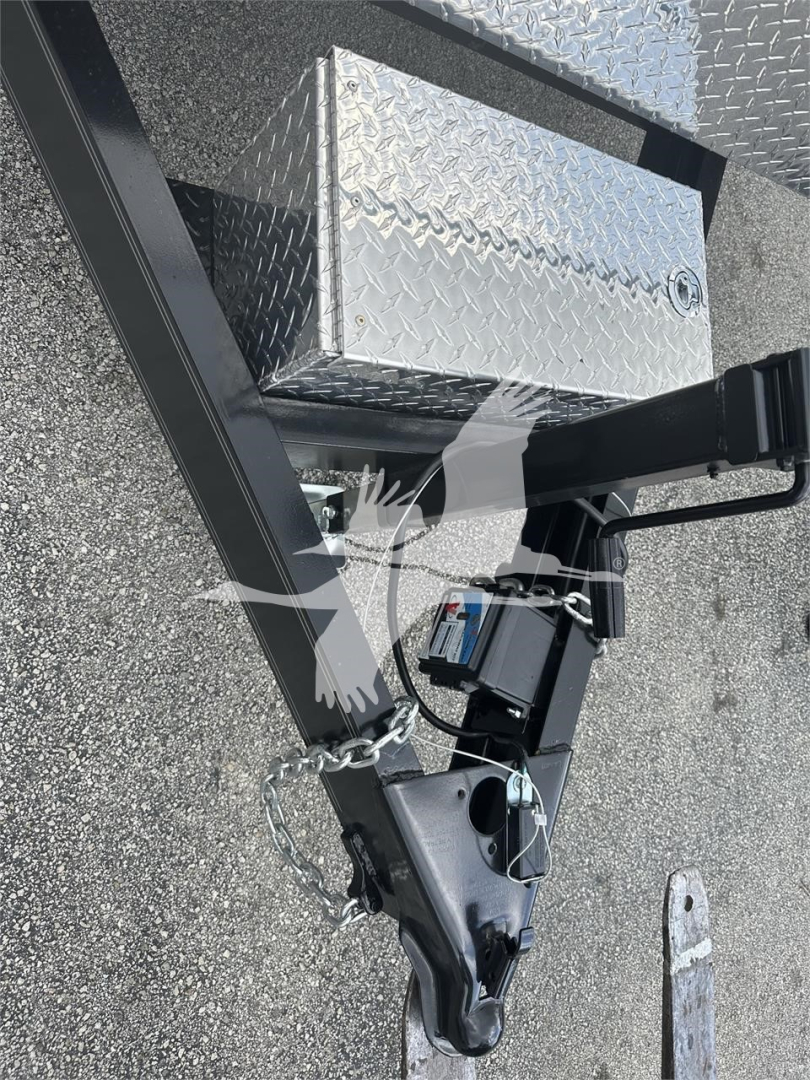 Trailer hitch with diamond plate toolbox and stabilizer hitch showing front of trailer frame and safety chains.