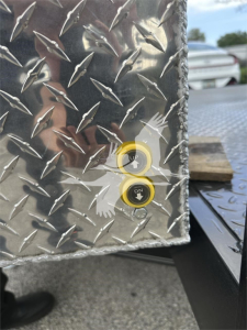 Diamond plate metal surface with two yellow cone buttons labeled OFF and ON on a trailer platform edge.