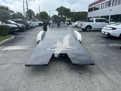 Flatbed trailer with loading ramp in open lot, shows stock number FZTR00733FM in equipment category