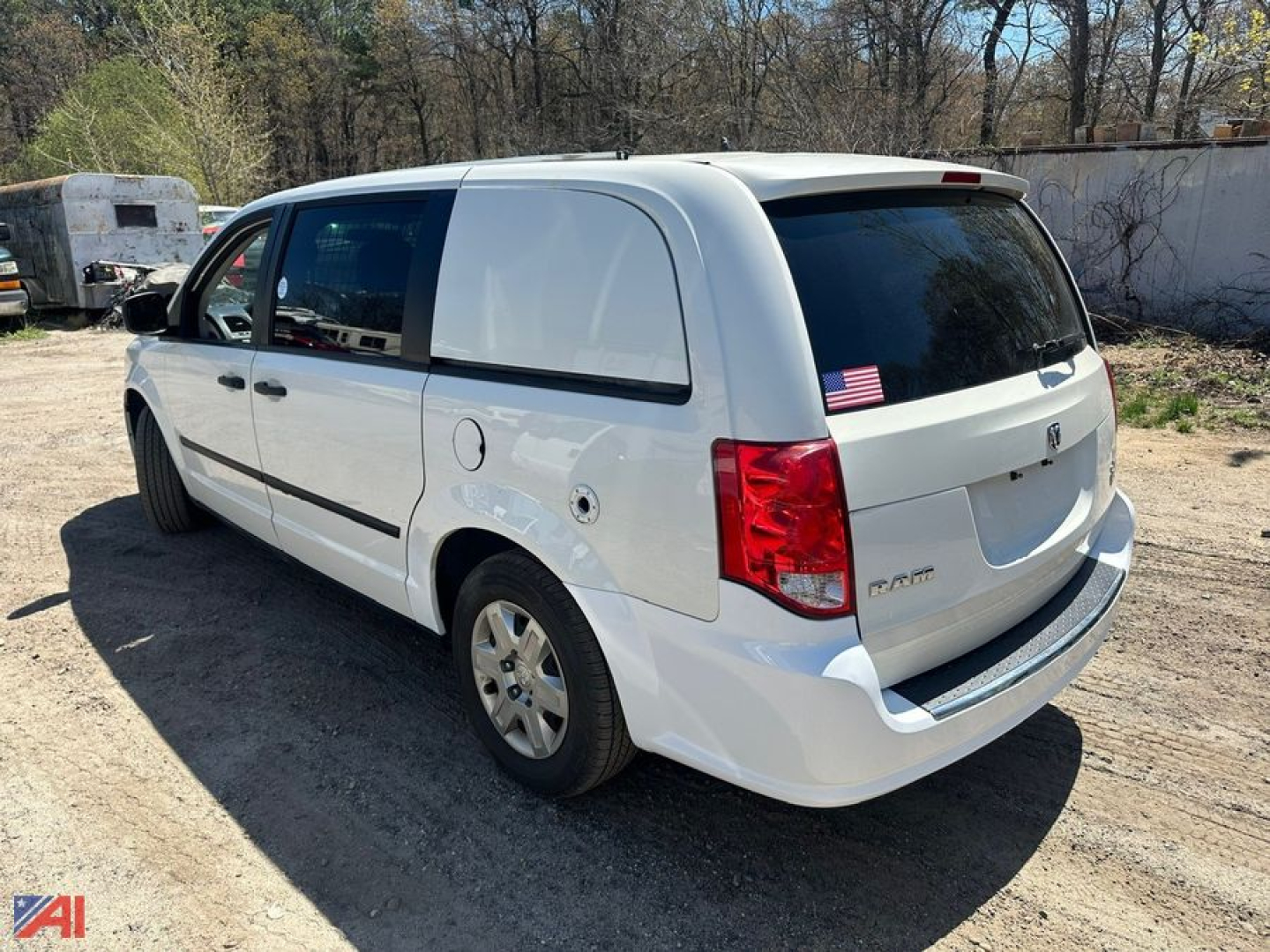 Cargo van showing rear and passenger-side in white, 2013 Dodge Ram, with rear hatch, taillights, and small American flag decal on rear window.