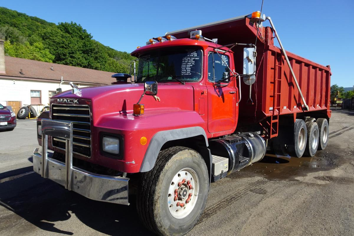 Mack RD RD688S dump truck showing red cab and dump bed from front-left angle with chrome bumper and grille.