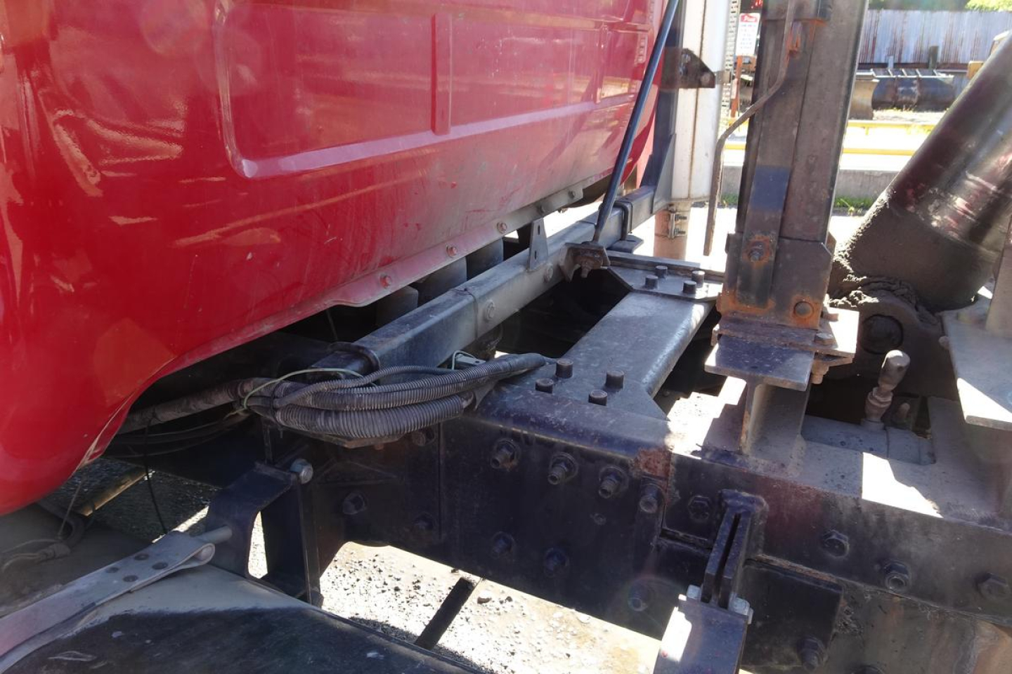 Mack RD RD688S dump truck chassis showing underbody frame and hydraulic lines near the cab with red body panel.