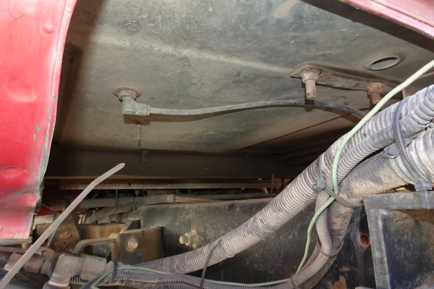 Truck engine bay showing wiring harnesses and under-hood components in a Mack RD RD688S dump truck.