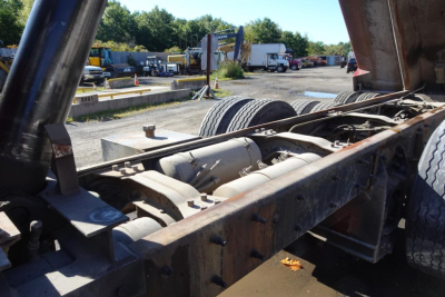 Chassis view of a 2004 Mack RD RD688S dump truck showing undercarriage, frame rails, and drivetrain components.