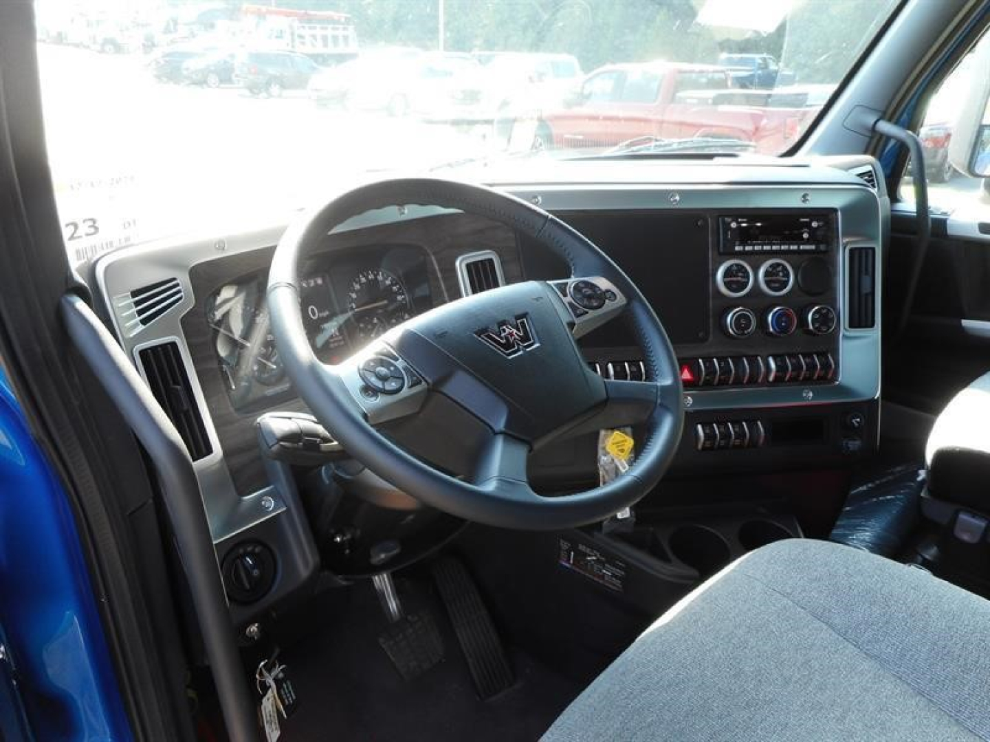 Truck cabin interior showing steering wheel and dashboard with digital display and controls in a Western Star 47X.