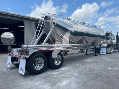 Heil Super Jet 1040 pneumatic dry bulk trailer side and rear view showing polished stainless steel tanker and dual rear axles with mud flaps.
