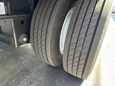 Trailer wheel area showing two rear tires and part of drop deck with beadlock and suspension components.