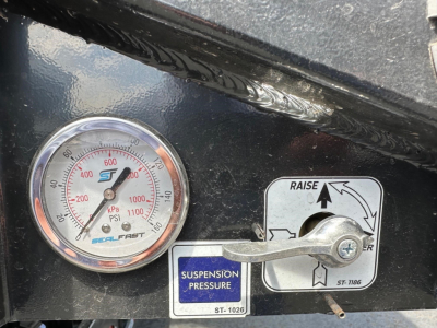 Trailer gauge panel showing suspension pressure gauge and control lever with labels, including raise lever and ST-1026 label.