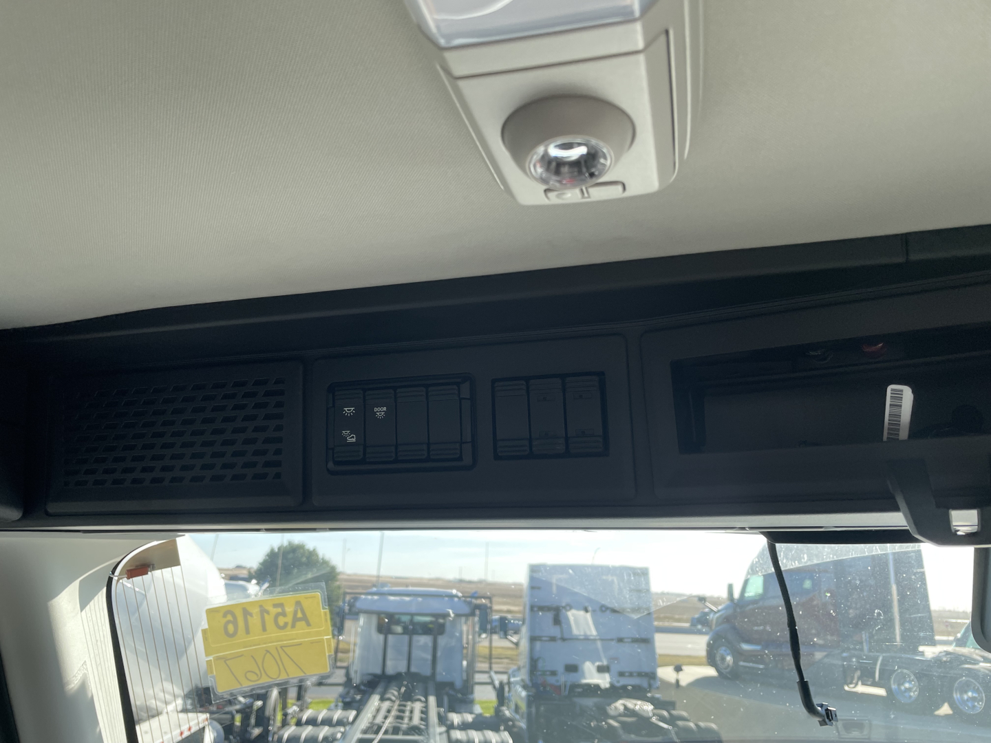 Interior overhead area of a Mack PR64T cab with control panel and sun visor; no readable labels or numbers visible on the panel.