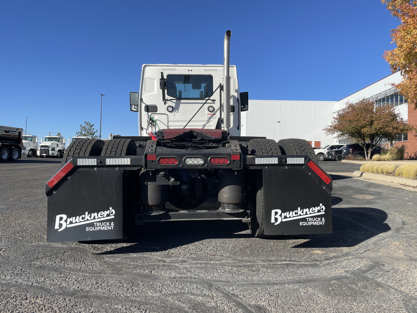 Rear view of a 2026 Mack PR64T truck showing dual rear mud flaps with 'Bruckners TRUCK & EQUIPMENT' branding, chassis, and fifth-wheel area visible.