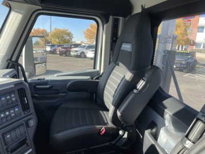 Inside truck cab of a 2026 Mack PR64T showing driver seat and controls with beige/gray interior.