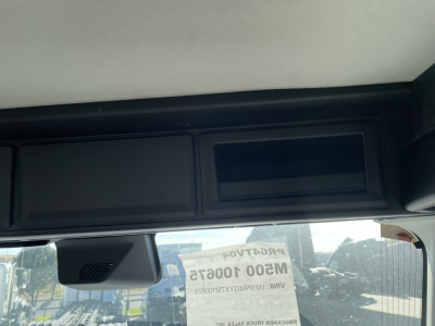 Cab interior of a 2026 Mack PR64T truck showing a dashboard display panel and overhead compartment.