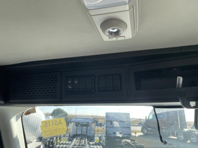 Interior overhead area of a Mack PR64T cab with control panel and sun visor; no readable labels or numbers visible on the panel.