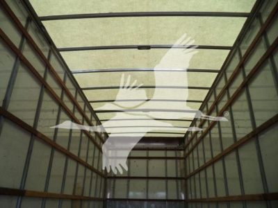 Cargo box truck interior trailer showing empty walls and ceiling framing in a dimly lit space.