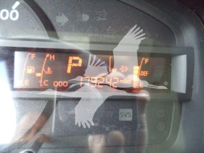 Dashboard display showing odometer reading 179,242 miles with fuel gauge and warning icons in orange.