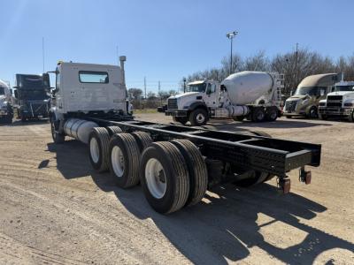 Volvo VHD86B300 cab and chassis rear view showing tri-axle frame, rear wheels, fuel tank, and chassis rails.
