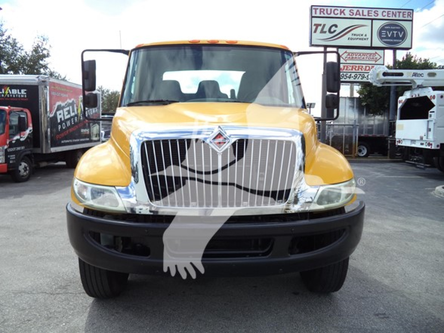 Front view of a yellow 2019 International Durastar 4300 rollback truck with a ferrule grille. Visible text includes VIN and stock info on listing and signs in background.