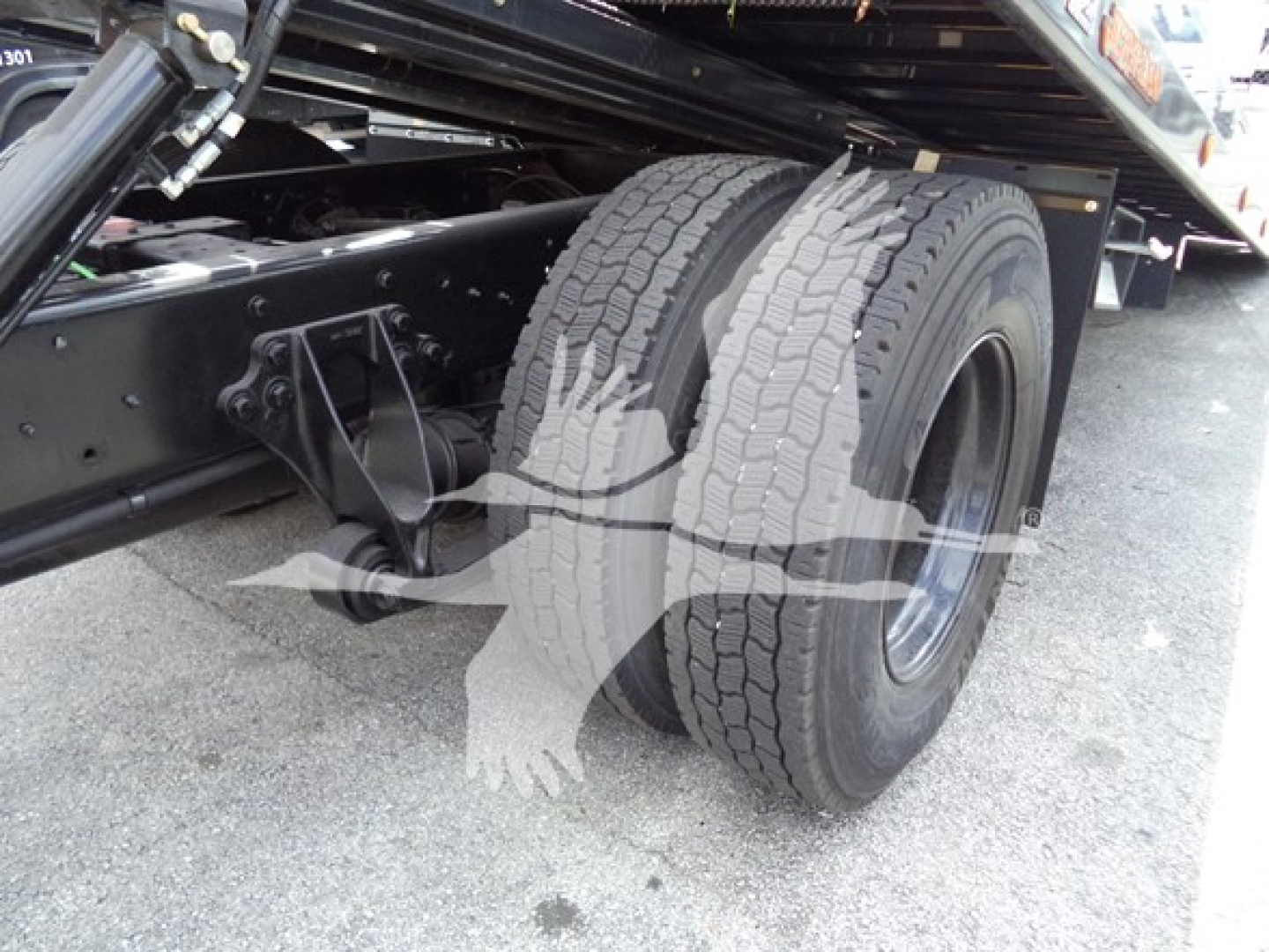 Truck rear dual tires and chassis frame of a 2019 International Durastar 4300 rollback truck showing dual rear wheels and suspension components.