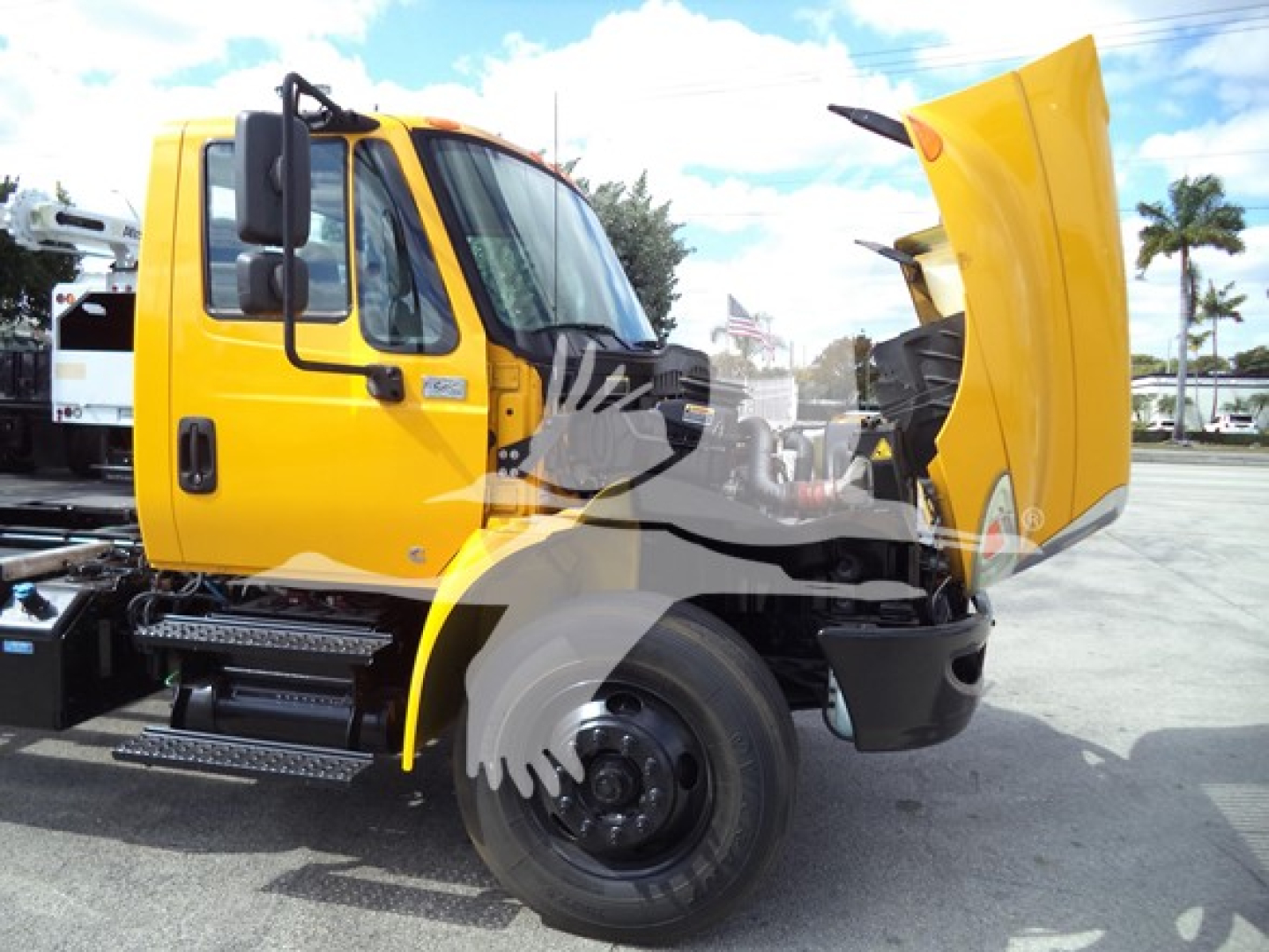 International Durastar 4300 rollback truck side view showing cab and raised hood with yellow paint and black chassis.