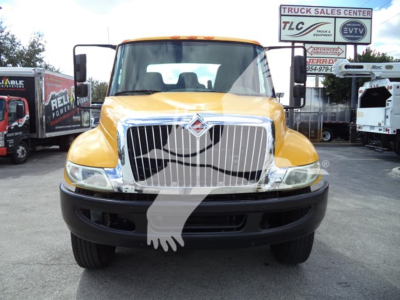 Front view of a yellow 2019 International Durastar 4300 rollback truck with a ferrule grille. Visible text includes VIN and stock info on listing and signs in background.