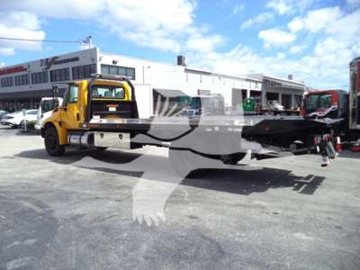 2019 International Durastar 4300 rollback truck with yellow cab and flatbed in a dealership lot.