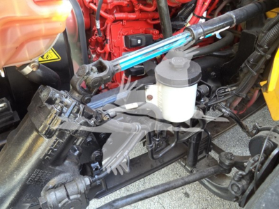 International Durastar 4300 truck engine bay showing hydraulic reservoir, red engine block, and various hoses and lines.