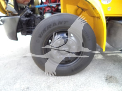 Truck wheel and fender area of a 2019 International Durastar 4300 rollback showing QuikTrant tire and yellow body panel.