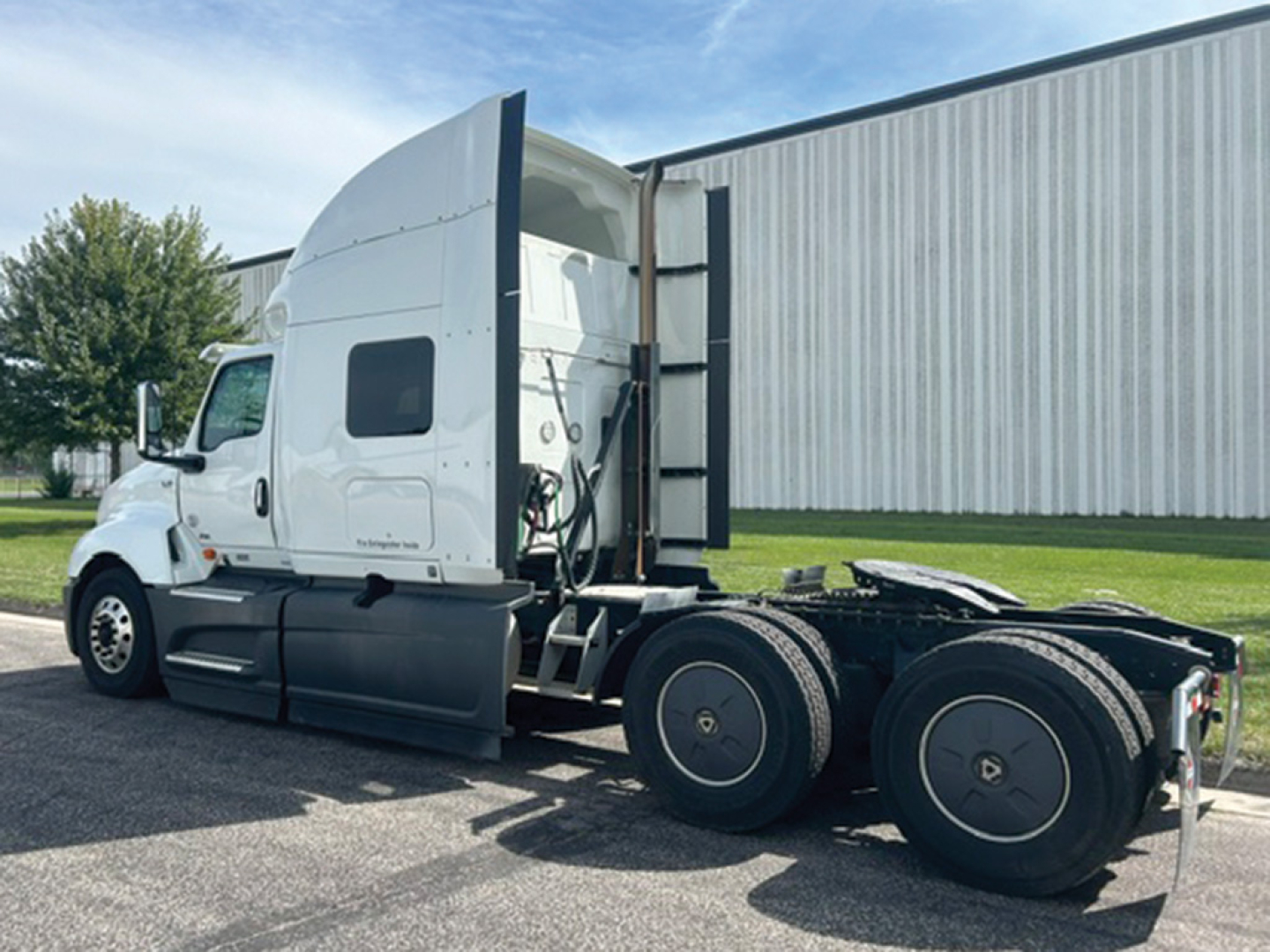 Truck cab and chassis of a 2023 International LT625 with sleeper cab, side view showing rear dual axles and fifth wheel area.