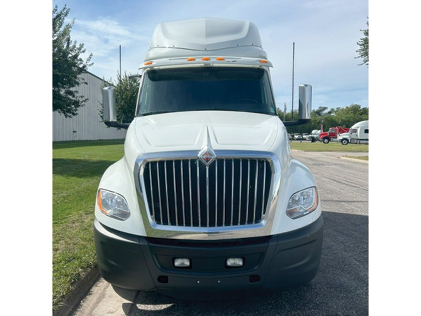 Truck front view of a white 2023 International LT625 with prominent grille and large bumper.